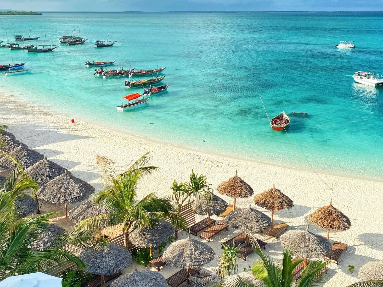 Zanzibar beach resort with turquoise water and traditional boats