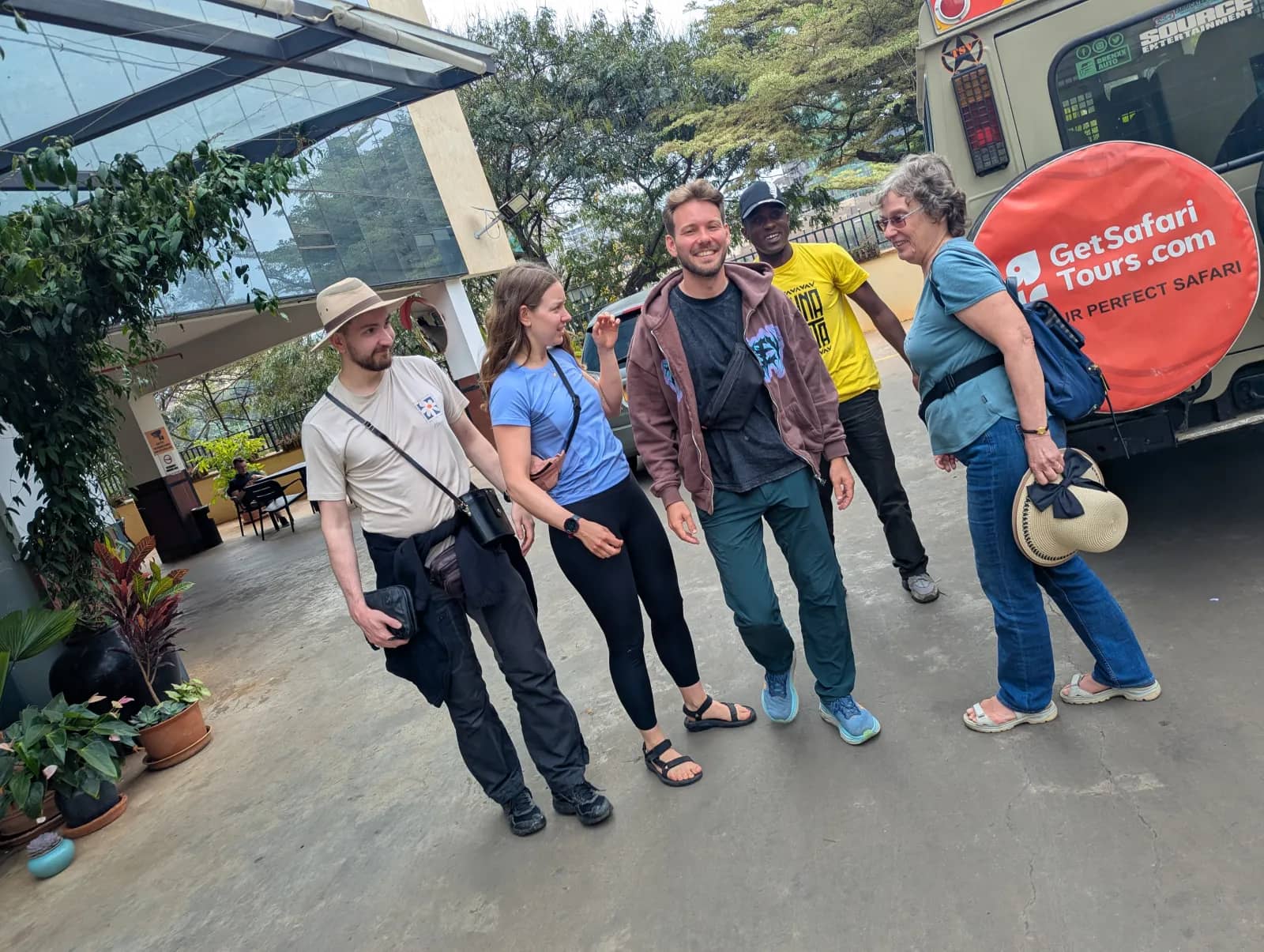 Karlis with a client family and their guide beside a GetSafariTours vehicle